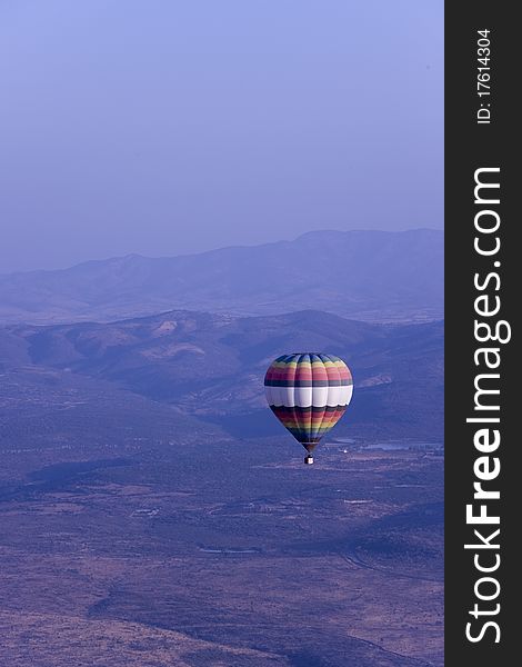 Single Hot Air Balloon Flying In Mountains