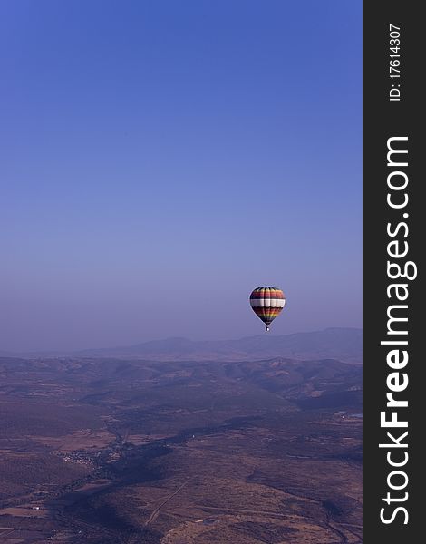 Single Hot Air Balloon Flying In Mountains