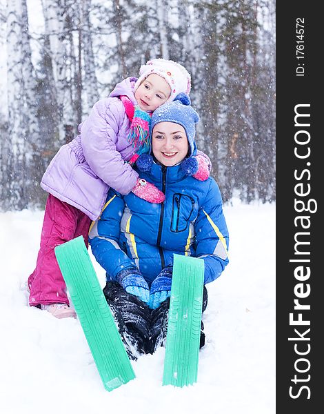 Happy mother and daughter, the family for a walk in a winter park, luge, skiing, skating, snowballs. Happy mother and daughter, the family for a walk in a winter park, luge, skiing, skating, snowballs