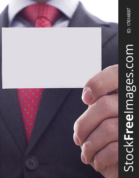 Businessman in grey suit and a blue shirt with a red power tie, shows businesscard with copy space, shallow dept of field. Businessman in grey suit and a blue shirt with a red power tie, shows businesscard with copy space, shallow dept of field