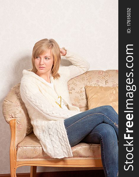 Young woman sits on a sofa