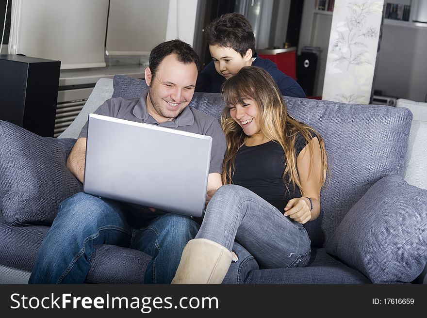 Smiling teenagers and little boy looking at the laptop screen. Smiling teenagers and little boy looking at the laptop screen