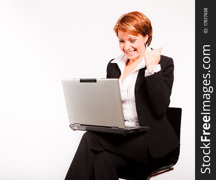 Beautiful business woman with laptop sitting on chair