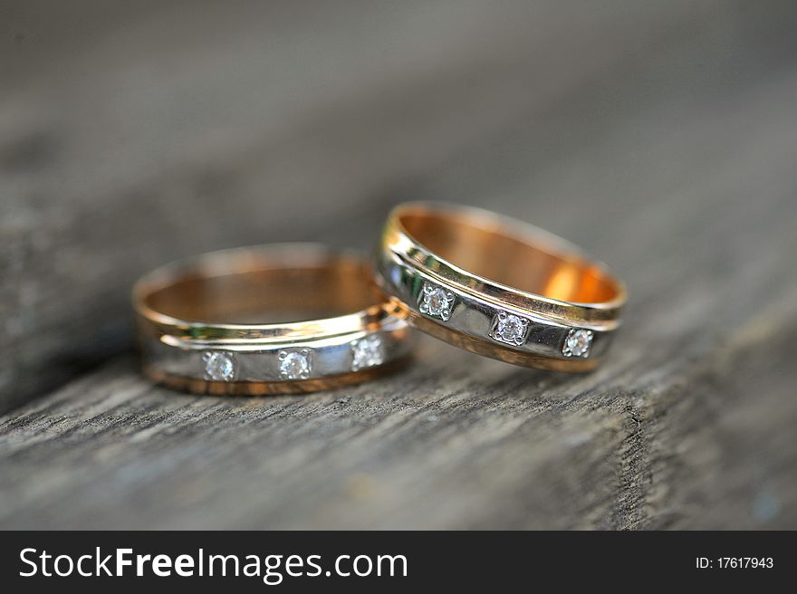 Two golden wedding rings on wooden background