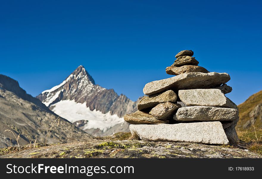 A Stone totem in contrast with a real mountain