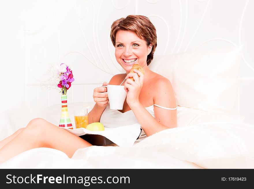 Beatiful woman having breakfast in white bed. Beatiful woman having breakfast in white bed