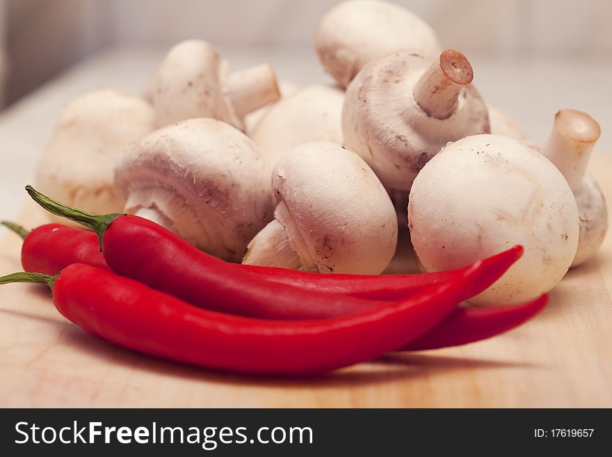 Red hot chili pepper and mushrooms, On a board for cooking