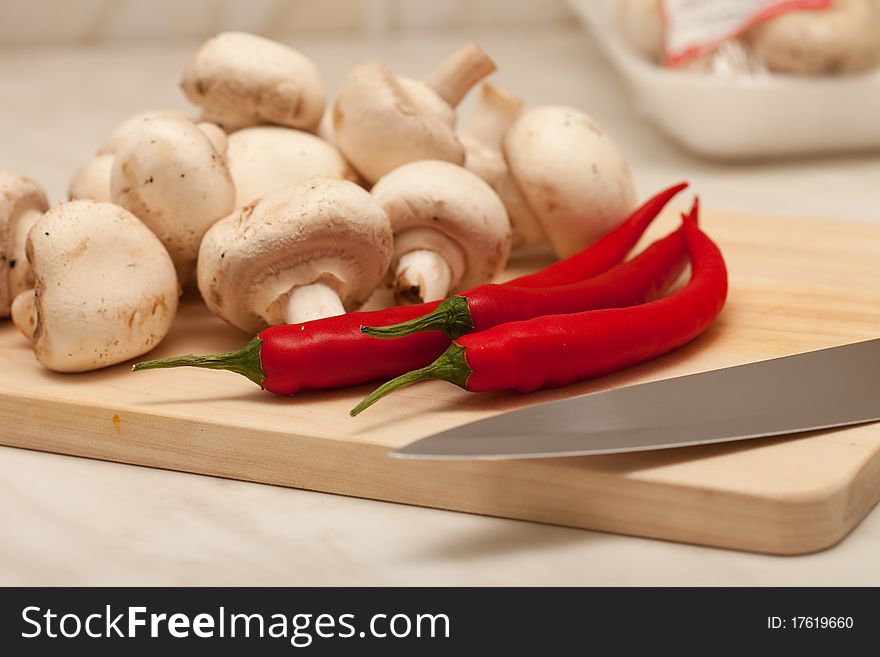 Red hot chili pepper and mushrooms, On a board for cooking