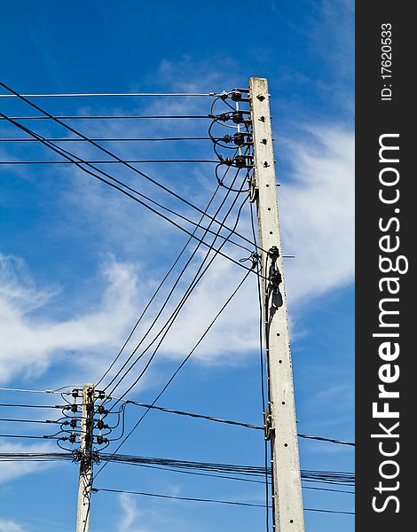 Two electricity poles and wires with blue sky