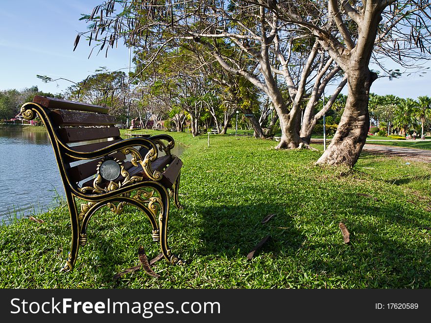 Alloy and wooden bench on the waterside in the public park. Alloy and wooden bench on the waterside in the public park