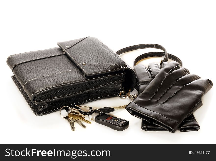 A woman's black purse, driving gloves and a set of keys. Isolatated on white. A woman's black purse, driving gloves and a set of keys. Isolatated on white.