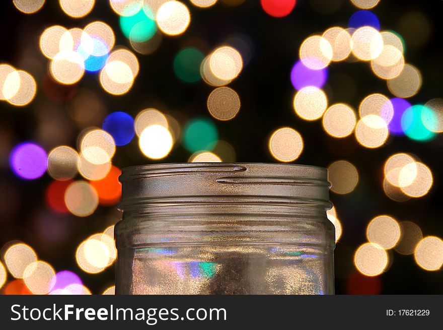 Clear glass jar with magical bokeh dots popping out. Isolated on black background. Clear glass jar with magical bokeh dots popping out. Isolated on black background