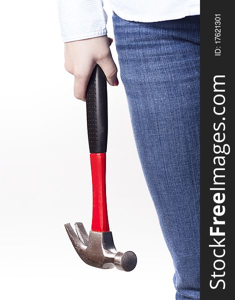 A woman in blue jeans and a button up shirt holding a hammer at her side. A high key portrait on a white background. A woman in blue jeans and a button up shirt holding a hammer at her side. A high key portrait on a white background.