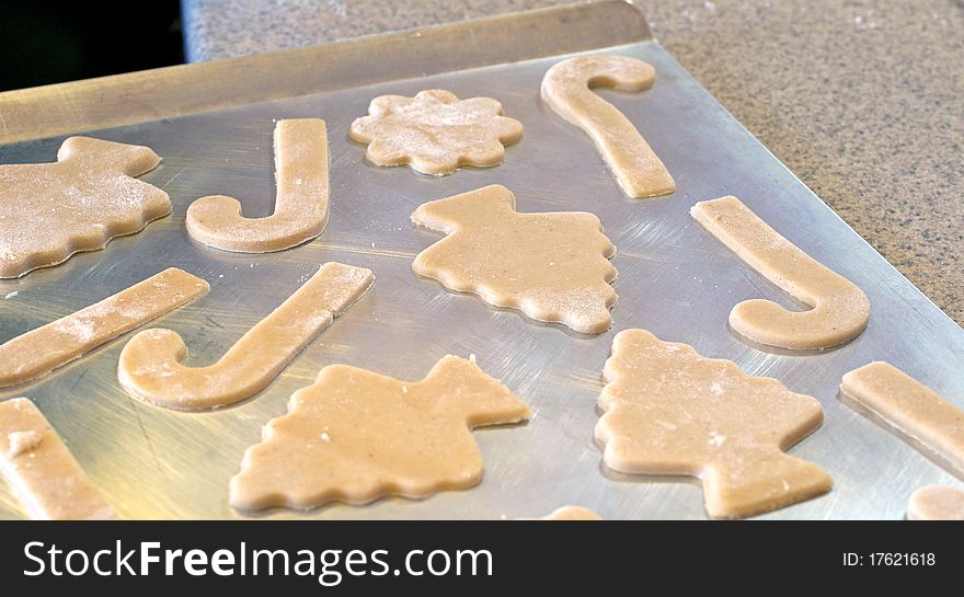 Cutting out Christmas sugar cookies on a cutting board. Cutting out Christmas sugar cookies on a cutting board.