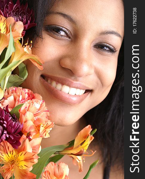 Beautiful young female peers around a fresh bouquet of flowers. Beautiful young female peers around a fresh bouquet of flowers.