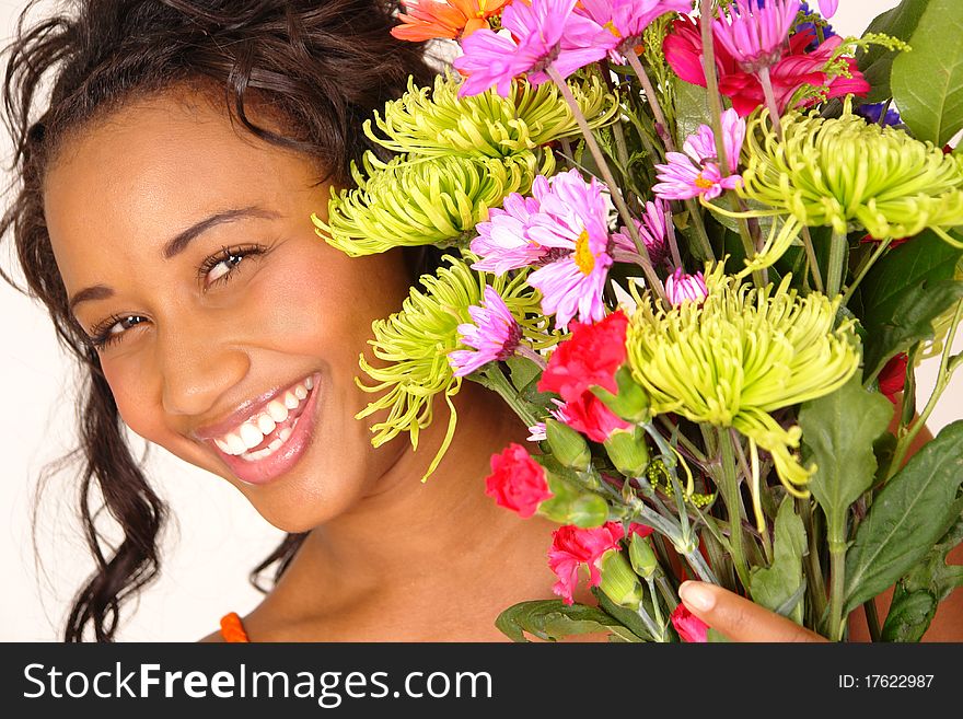 Pretty young smiling female peeks out from flower bouquet. Pretty young smiling female peeks out from flower bouquet.