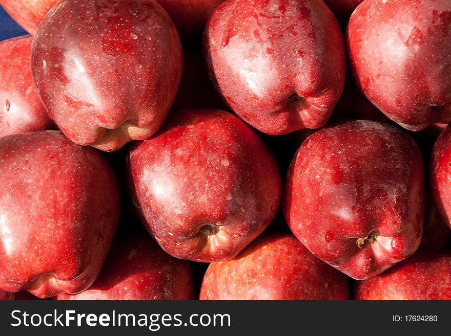 Background of red ripe apples with drops of dew