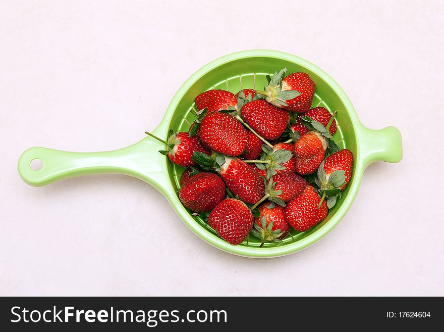 Ripe red strawberries in a green bowl