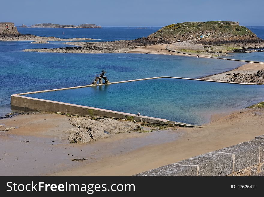 A natural swimming-pool gained by a tract of coast