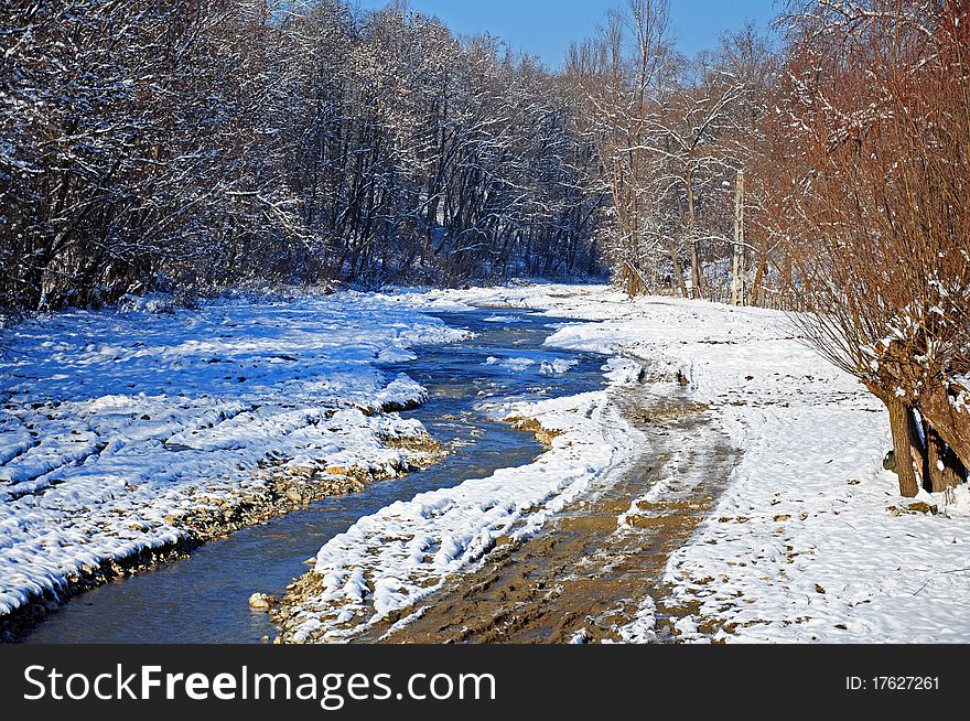 Snowy muddy trace near curved river