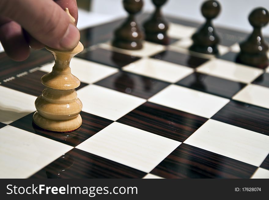 Man hand moving queen on chess table