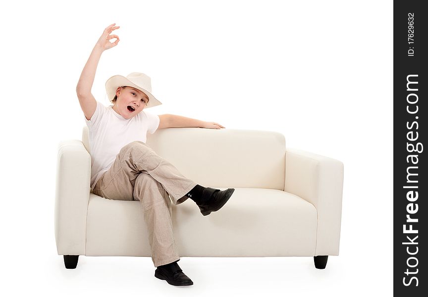 Portrait of a boy wearing a hat on a couch showing sign Ok