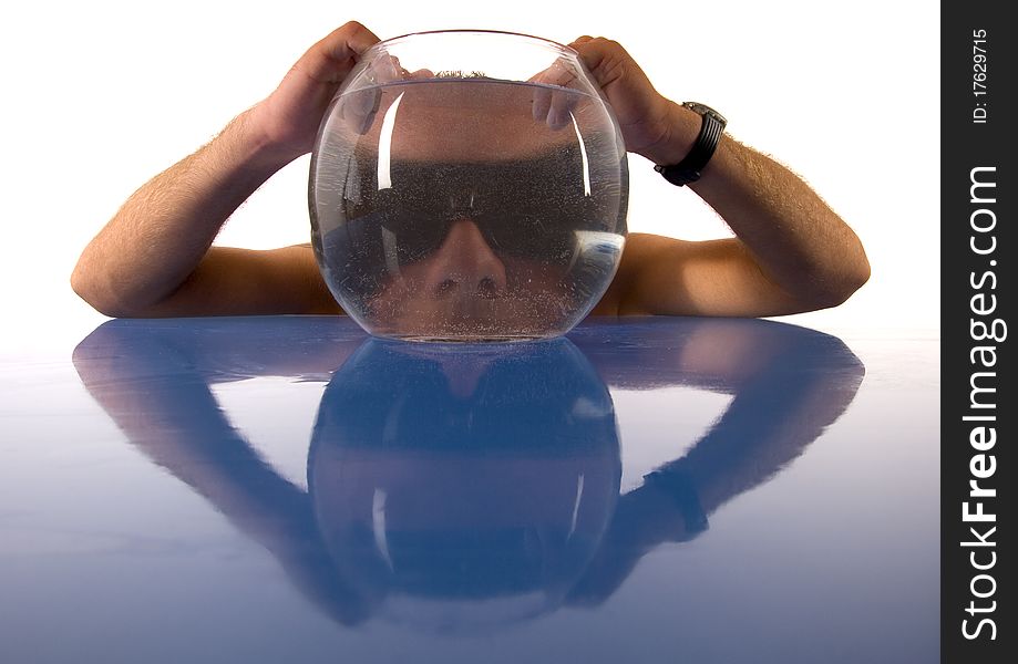 A funny situation with a smart man and Aquarium.A man sits at a glass desk and holds his head for the aquarium