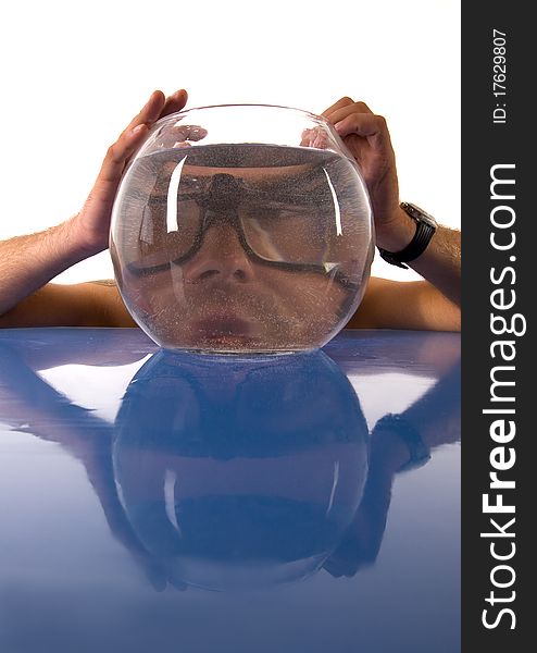 A funny situation with a smart man and Aquarium.A man sits at a glass desk and holds his head for the aquarium
