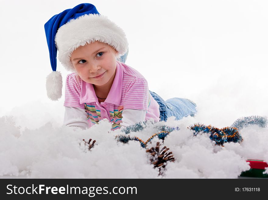 Beautiful girl in Santa's hat in tinsel and artificial snow isolated on white