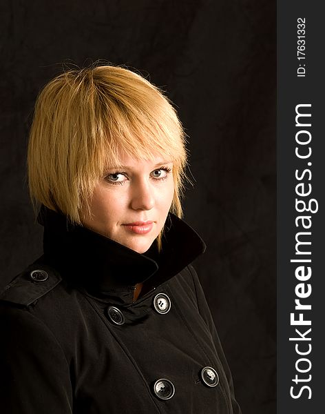 Blond woman in black trench coat.