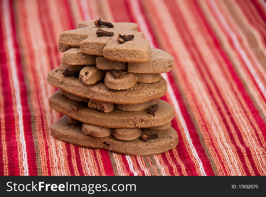 Stack of homemade gingerbread cookies on Christmas decorative red napkin