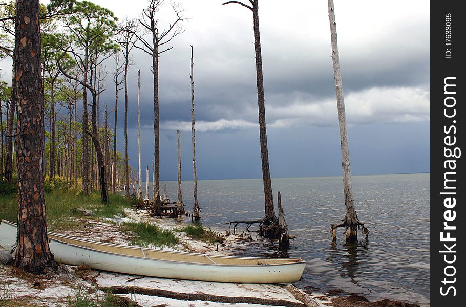 Canoe on shoreline with storm approaching. Canoe on shoreline with storm approaching