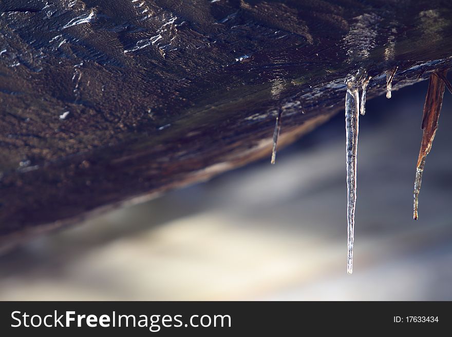 Ice hanging from wood beam on a bridge