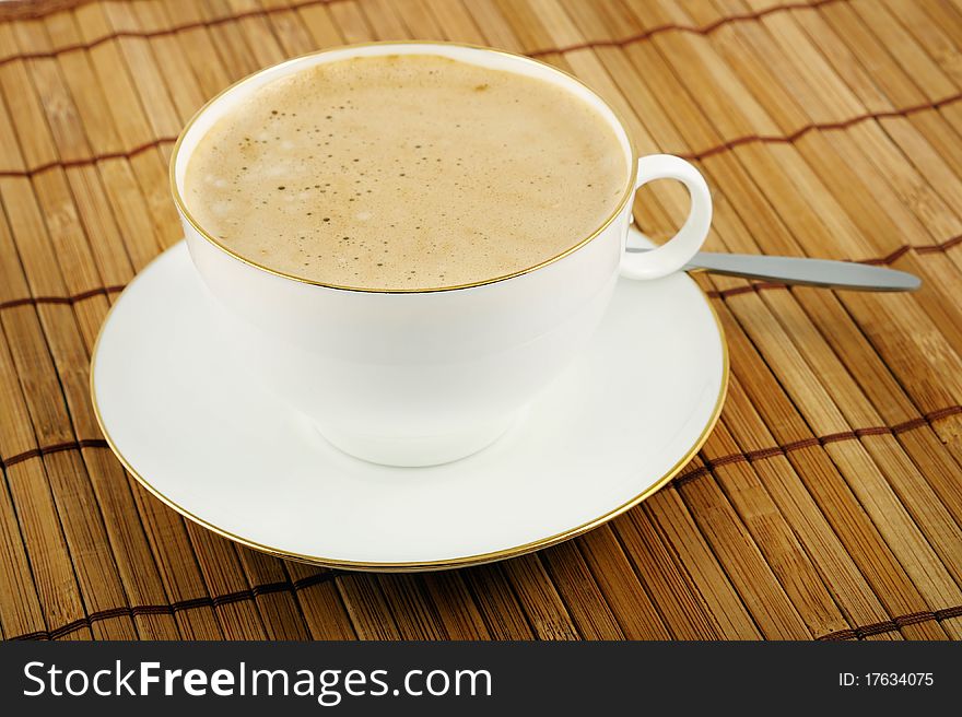 Classic white cup cappuccino and saucer with teaspoon. Closeup