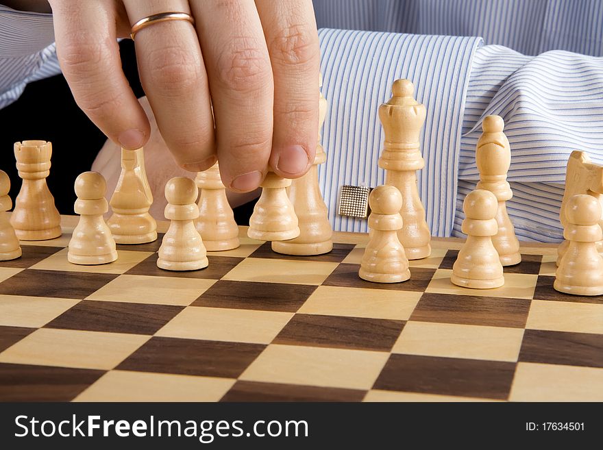 Male hand moving chess piece