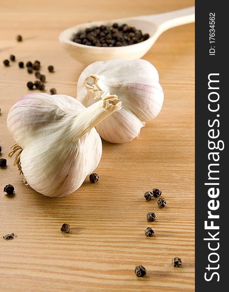 Garlic and pepper on wooden spoon