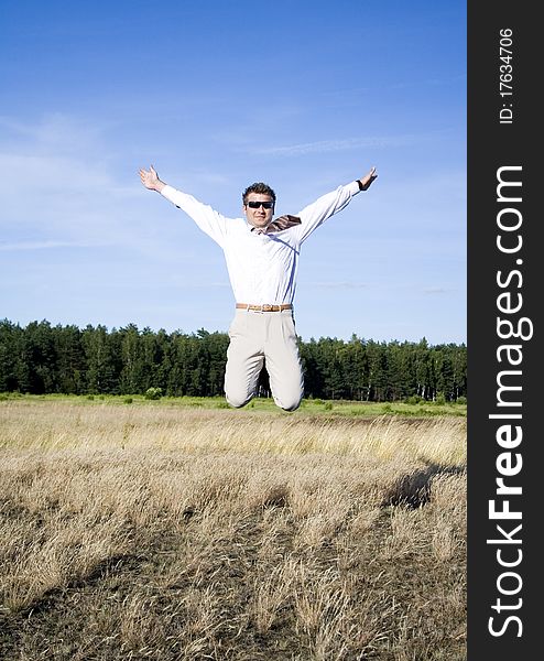 Businessman dressed in an elegant suit, jumping with joy in nature. Businessman dressed in an elegant suit, jumping with joy in nature