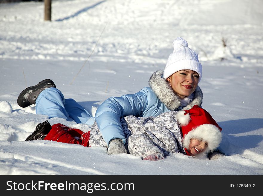 Mother And Daughter Playing In The Snow