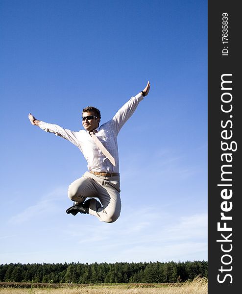 Businessman dressed in an elegant suit, jumping with joy in nature. Businessman dressed in an elegant suit, jumping with joy in nature