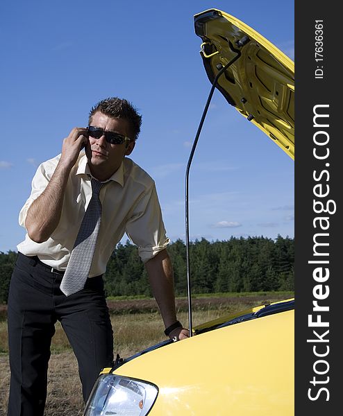 A businessman dressed in a smart suit standing on grass and talking on mobile phone. A businessman dressed in a smart suit standing on grass and talking on mobile phone.