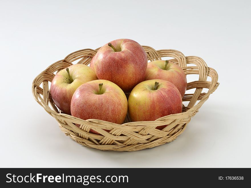 Fresh red apples in a basket. White background.