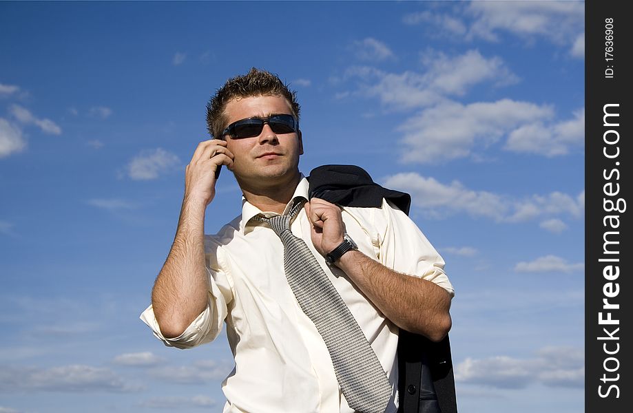 A businessman dressed in a smart suit standing on grass and talking on mobile phone. A businessman dressed in a smart suit standing on grass and talking on mobile phone.