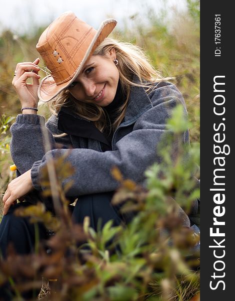 Beautiful girl in brown hat in field