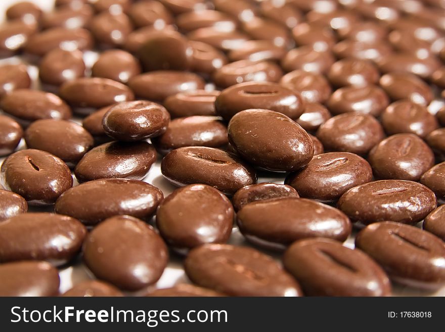 Delicious chocolate beans against white background