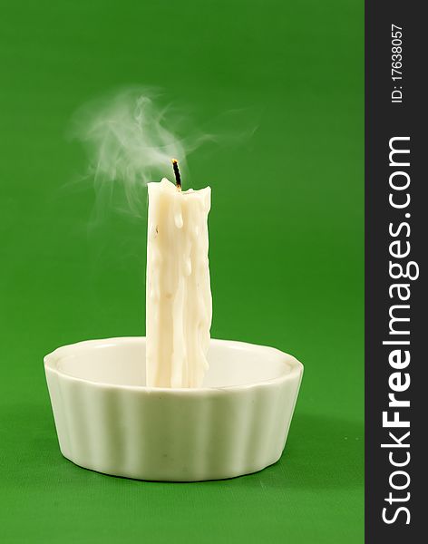 Unlit candle Spotlight on green background