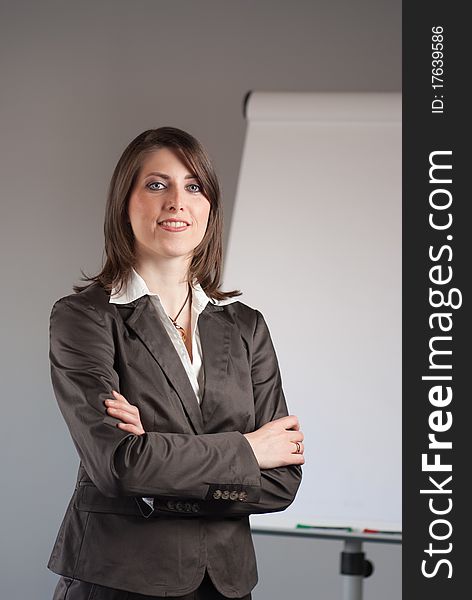 Young business woman standing in front of a flipchart. Young business woman standing in front of a flipchart