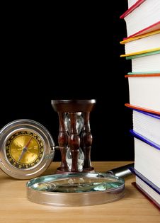 Pile Of Books, Compass And Hourglass On Black Stock Photo