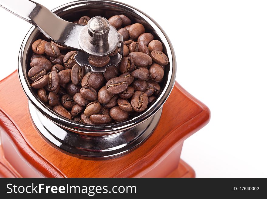 Coffee grinder made of a tree and metal and the roasted coffee beans on a white background. Coffee grinder made of a tree and metal and the roasted coffee beans on a white background