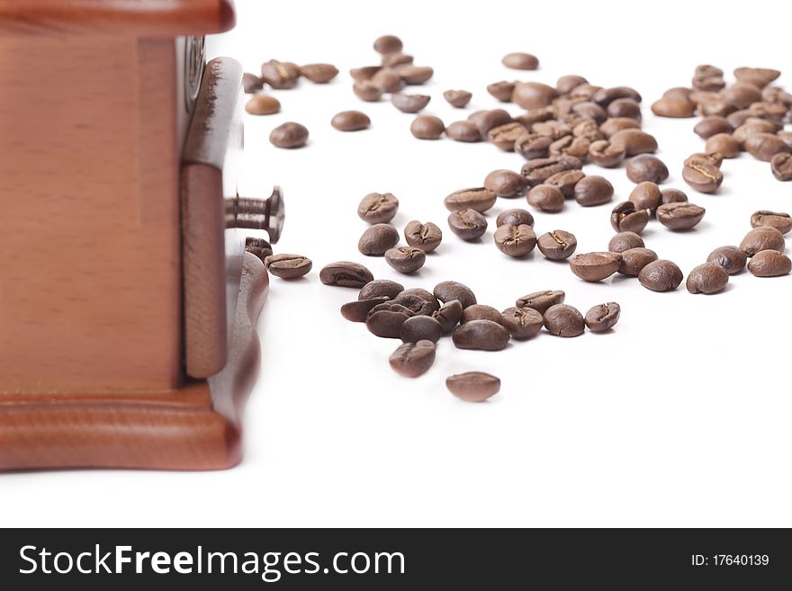 Coffee grinder made of a tree and metal and the roasted coffee beans on a white background. Coffee grinder made of a tree and metal and the roasted coffee beans on a white background