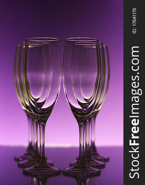 Empty champagne glasses on purple background